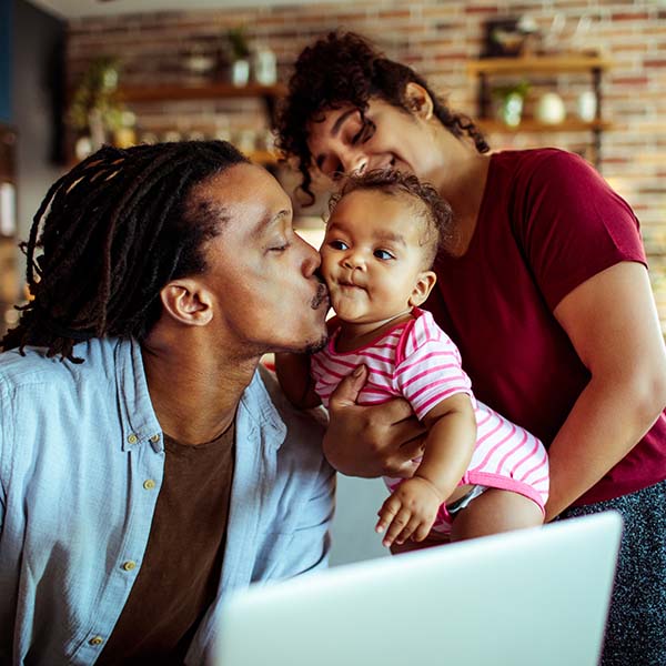 Family in their living room using a laptop
