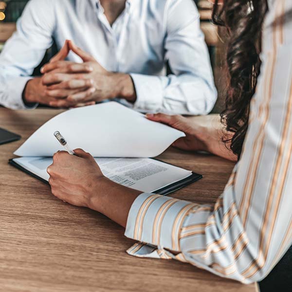 Female businessperson signs contract.